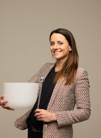 Clémence Cloué, sonothérapeute, tenant un bol chantant et un diapason